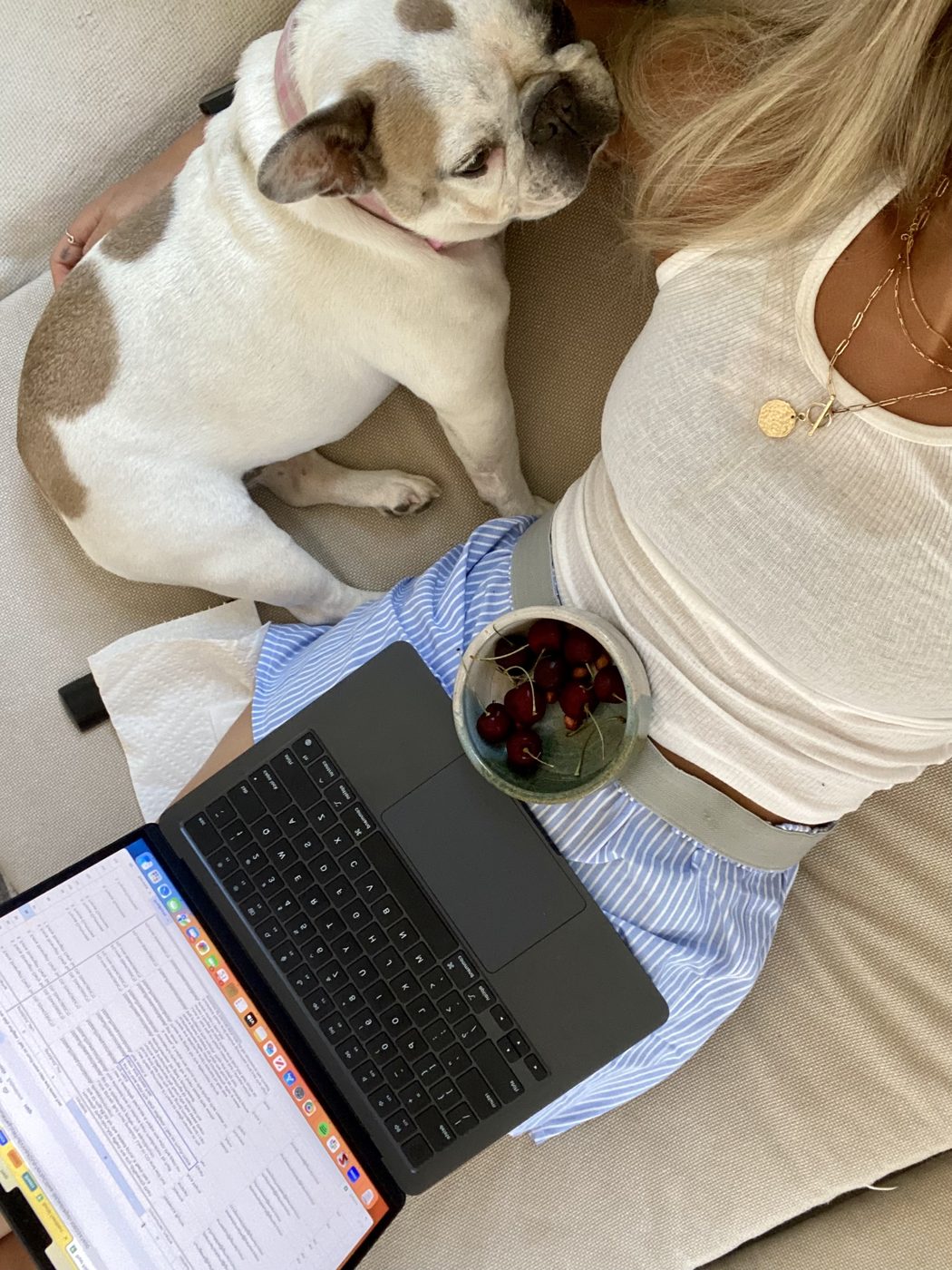 The organizer planning a trip on a laptop late at night with a drink and phone
